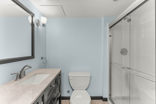 bathroom featuring toilet, a shower stall, baseboards, and vanity