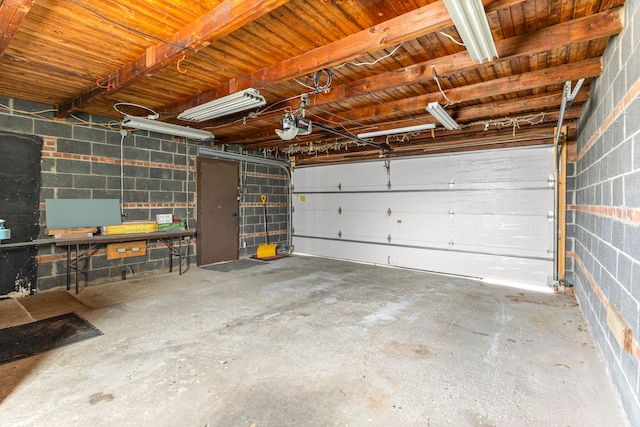 garage with concrete block wall and a garage door opener