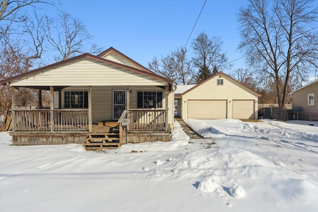 bungalow featuring covered porch, a detached garage, and an outbuilding