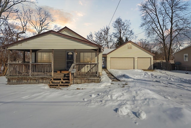 bungalow featuring a porch, an outbuilding, and a garage