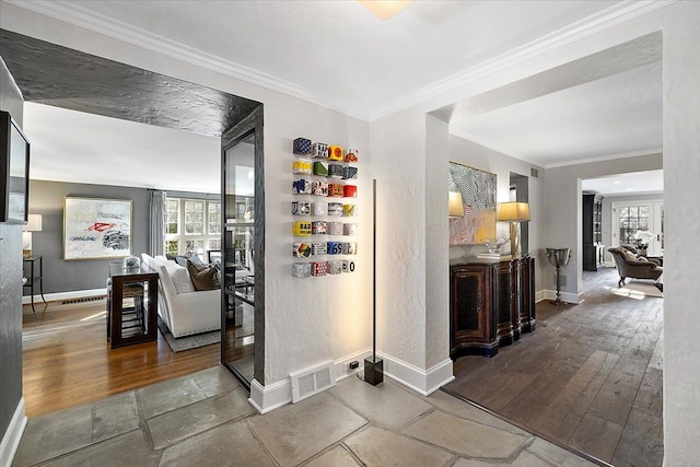 corridor featuring visible vents, baseboards, crown molding, and wood finished floors