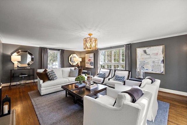 living room with a notable chandelier, crown molding, baseboards, and wood finished floors