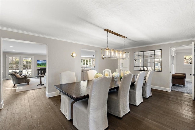 dining room featuring dark wood-style floors, crown molding, a textured ceiling, and baseboards