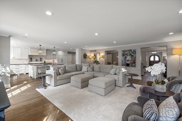 living room with ornamental molding, wood finished floors, and recessed lighting