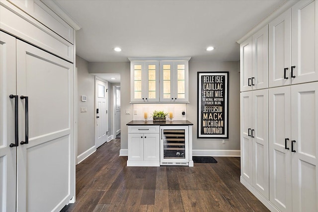 bar with tasteful backsplash, wine cooler, dark wood-type flooring, and recessed lighting