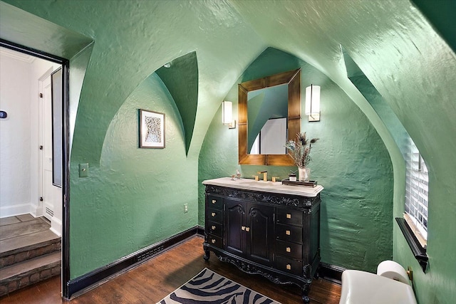 bathroom with a textured wall and wood finished floors