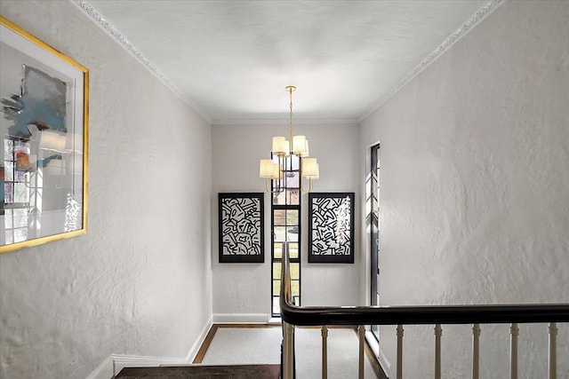 stairway with crown molding, baseboards, a notable chandelier, and a textured wall