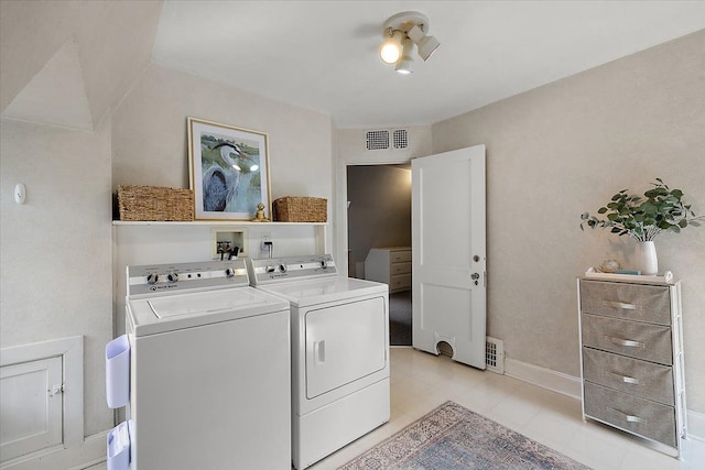 washroom with light tile patterned floors, independent washer and dryer, visible vents, and baseboards