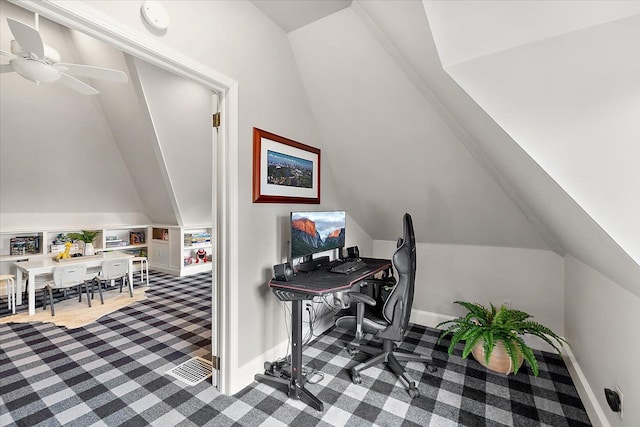 carpeted home office featuring vaulted ceiling, ceiling fan, and baseboards