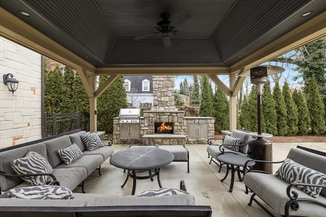 view of patio featuring a grill, fence, a gazebo, and an outdoor living space with a fireplace