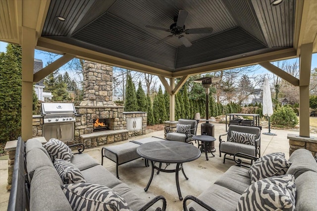 view of patio / terrace with grilling area, an outdoor living space with a fireplace, ceiling fan, and a gazebo