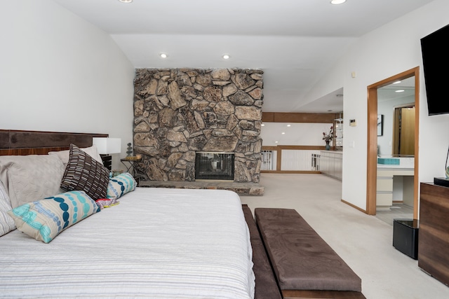 carpeted bedroom featuring recessed lighting, baseboards, vaulted ceiling, and a stone fireplace