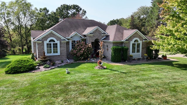 ranch-style home with brick siding, roof with shingles, and a front yard