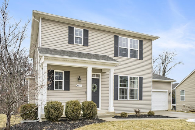 traditional home with roof with shingles, driveway, and an attached garage