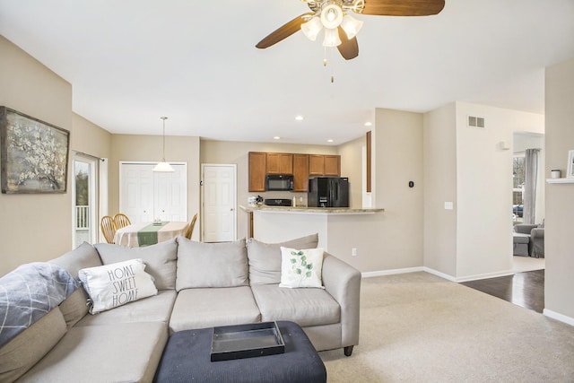 carpeted living area with ceiling fan, recessed lighting, visible vents, and baseboards