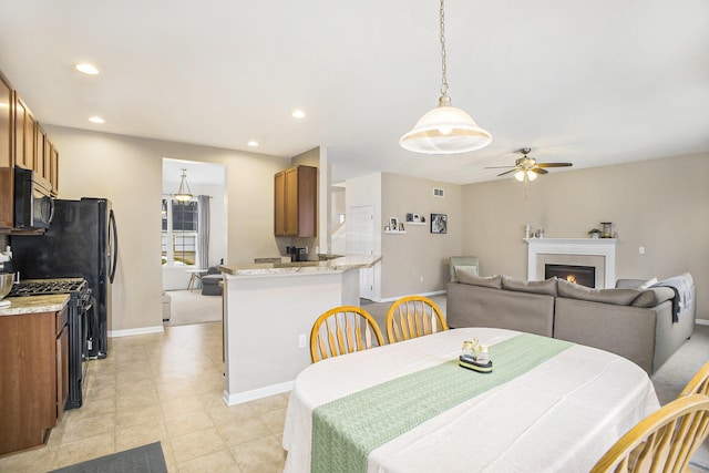 dining space with recessed lighting, visible vents, ceiling fan, a warm lit fireplace, and baseboards