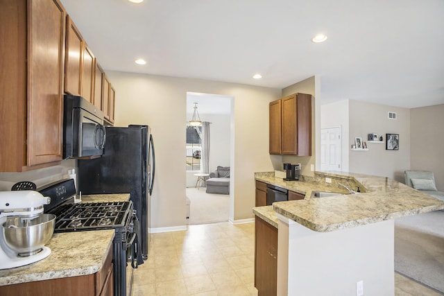 kitchen with recessed lighting, a peninsula, a sink, light countertops, and black appliances