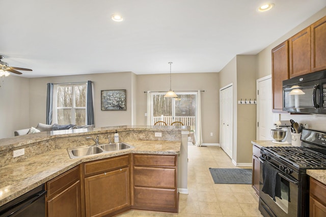 kitchen featuring a sink, baseboards, light stone countertops, black appliances, and decorative light fixtures