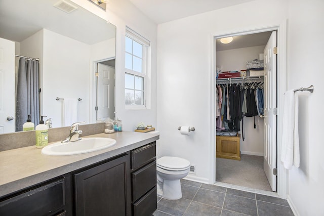 full bathroom with toilet, vanity, baseboards, visible vents, and tile patterned floors