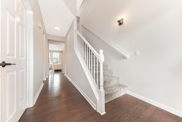 staircase featuring wood finished floors and baseboards