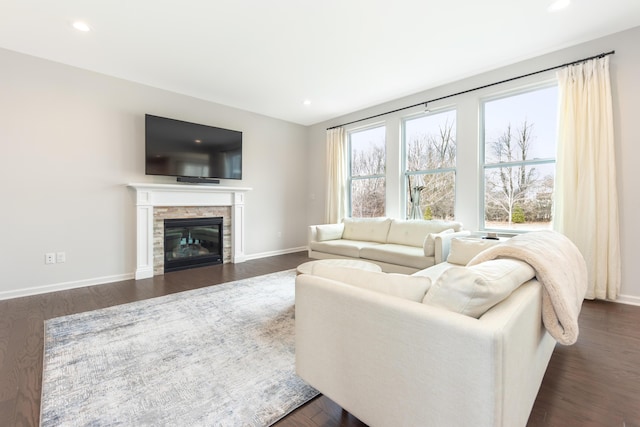 living room with a fireplace, baseboards, and dark wood-style flooring