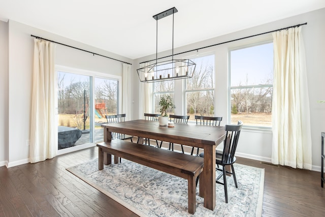 dining space featuring dark wood-style floors, visible vents, a notable chandelier, and baseboards