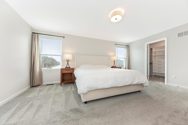 carpeted bedroom with visible vents, baseboards, and multiple windows