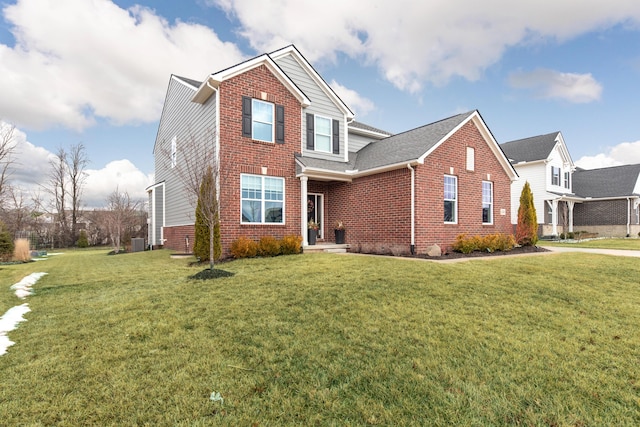 traditional-style home featuring a front yard, central AC, and brick siding