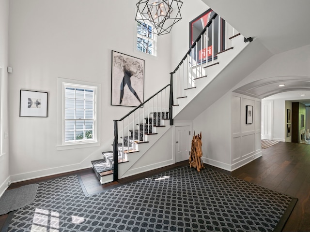 300 Warren Ct, Birmingham, MI 48009 - staircase with wood finished floors, a high ceiling, arched walkways, baseboards, and plenty of natural light