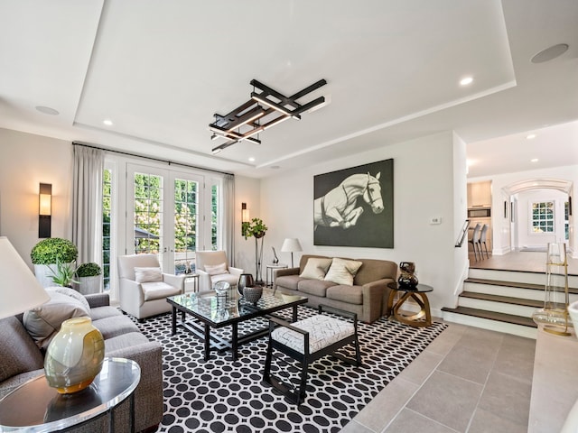 300 Warren Ct, Birmingham, MI 48009 - tiled living room featuring a tray ceiling, recessed lighting, stairs, and arched walkways