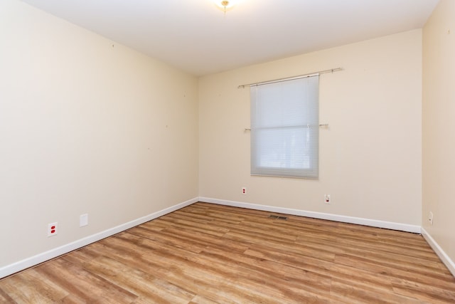 unfurnished room featuring light wood-type flooring and baseboards