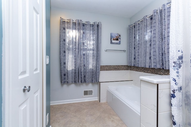 bathroom featuring visible vents, a garden tub, baseboards, and tile patterned floors