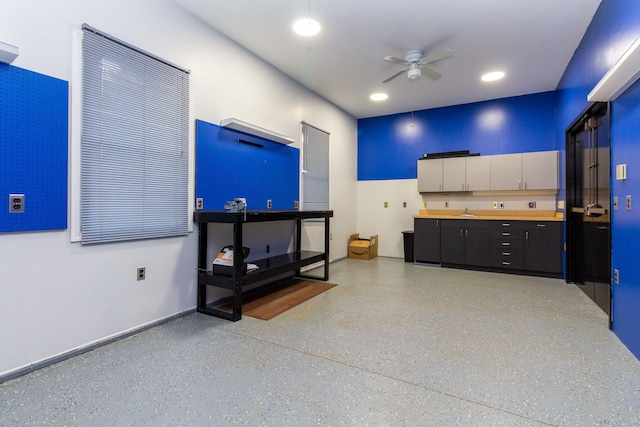 interior space with speckled floor, a ceiling fan, and recessed lighting