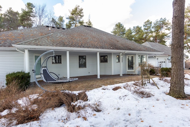 view of front facade with an attached garage and roof with shingles