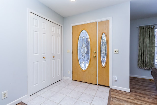 foyer featuring light wood-style flooring and baseboards