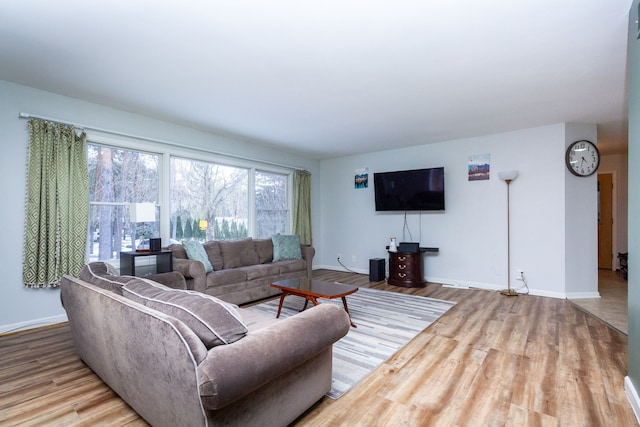 living area with baseboards and wood finished floors