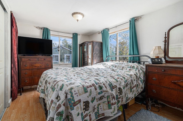 bedroom with light wood-type flooring and multiple windows