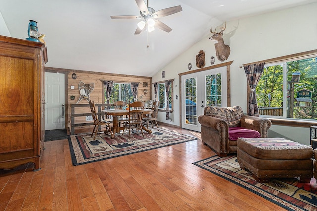 dining room featuring hardwood / wood-style flooring, high vaulted ceiling, a ceiling fan, and french doors