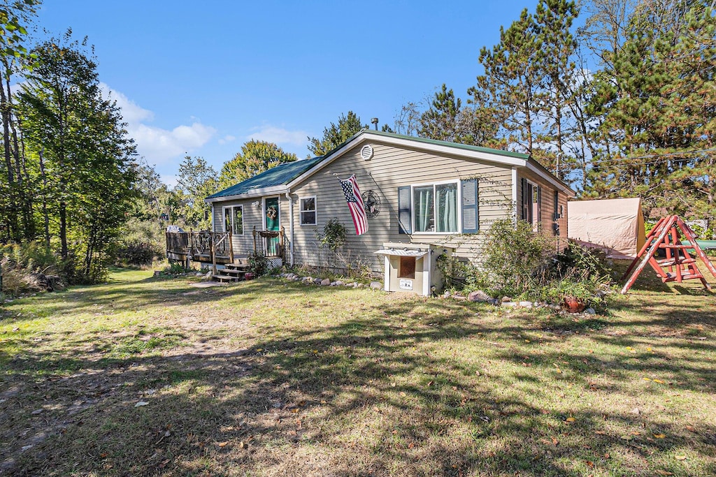 3459 N Morrie, White Cloud, MI 49349 - view of front of house with a deck, a front yard, and a playground