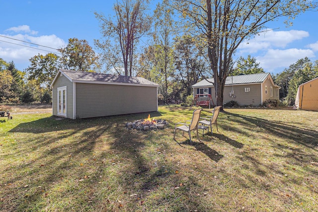 view of yard with an outbuilding and an outdoor fire pit