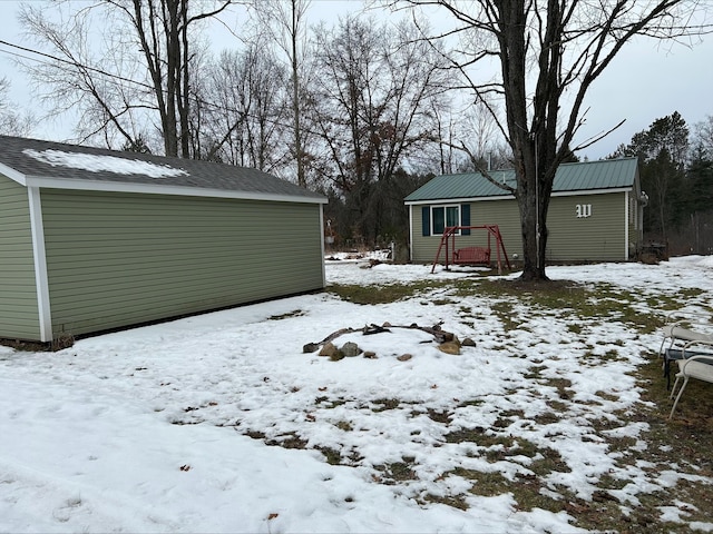 snowy yard featuring an outbuilding