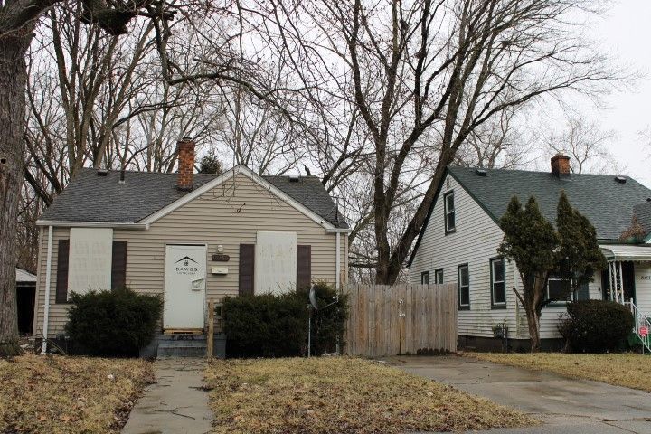 bungalow-style house featuring roof with shingles, a chimney, and fence