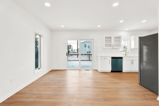 kitchen with freestanding refrigerator, light countertops, dishwasher, and light wood-style flooring