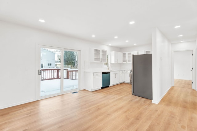 kitchen featuring a sink, visible vents, light wood-type flooring, freestanding refrigerator, and dishwasher