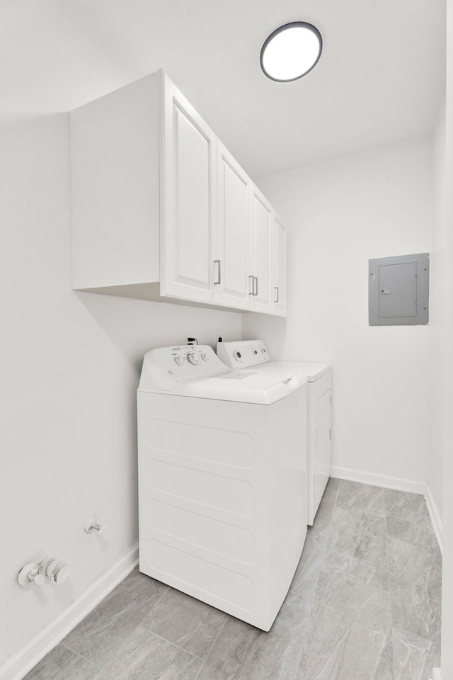 laundry area featuring independent washer and dryer, cabinet space, electric panel, and baseboards