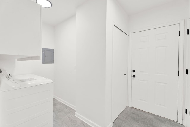 clothes washing area with washer and clothes dryer, light wood-style floors, laundry area, electric panel, and baseboards