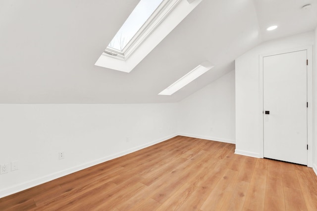 additional living space featuring lofted ceiling, light wood finished floors, baseboards, and recessed lighting