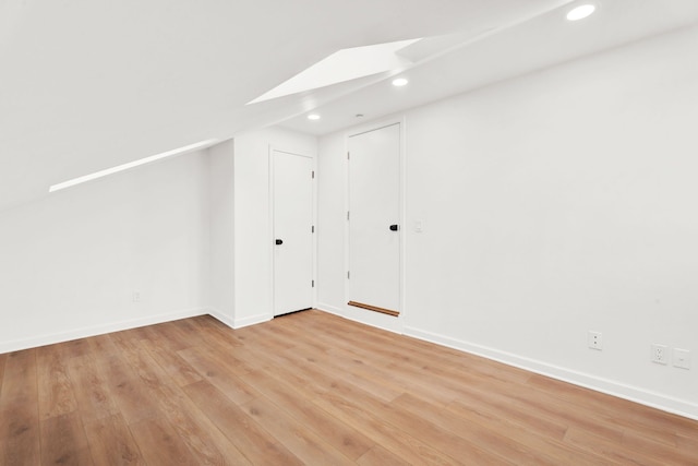 additional living space with light wood-type flooring, recessed lighting, a skylight, and baseboards