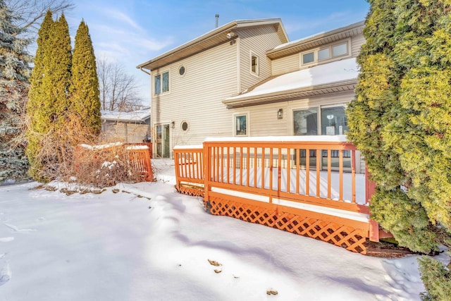 snow covered property with a wooden deck