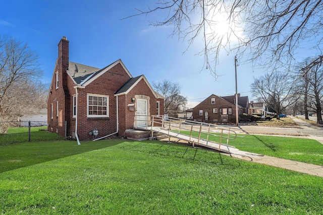 view of home's exterior featuring a yard, fence, brick siding, and a chimney